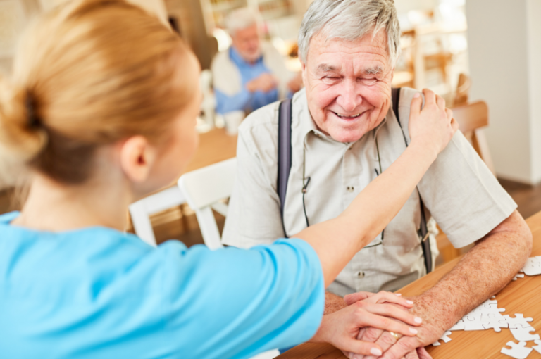 Caregiver comforting elderly man in a memory care setting, emphasizing companionship and support for seniors with Alzheimer's and dementia.