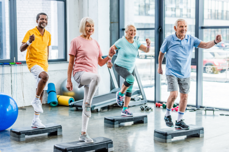 Seniors engaging in a group exercise class, stepping on fitness platforms, promoting physical activity and health for elderly individuals.