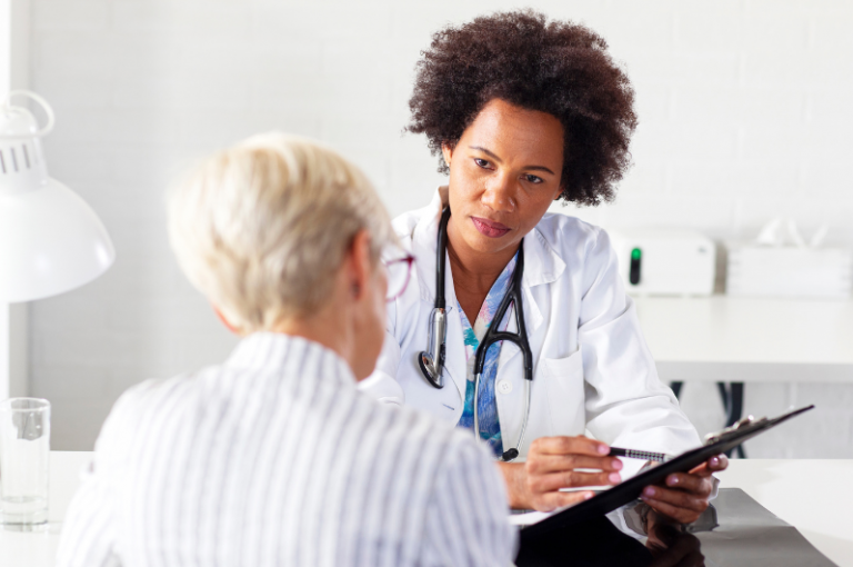 Doctor consulting with senior patient in medical office, discussing health issues and care options.