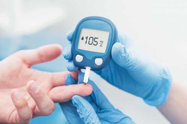 Blood glucose meter displaying 105 mg/dL while a healthcare professional checks a patient's blood sugar level, relevant to senior health and diabetes management.