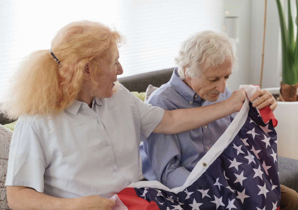 Caregiver assisting elderly veteran with American flag, emphasizing compassionate home care services for veterans.